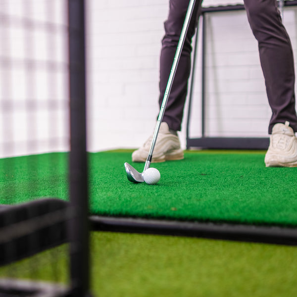 Golf simulator enclosure with golfer hitting a ball - Perfect your swing indoors with a SimBox.