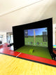 Spacious room set up with a SimBox golf simulator enclosure